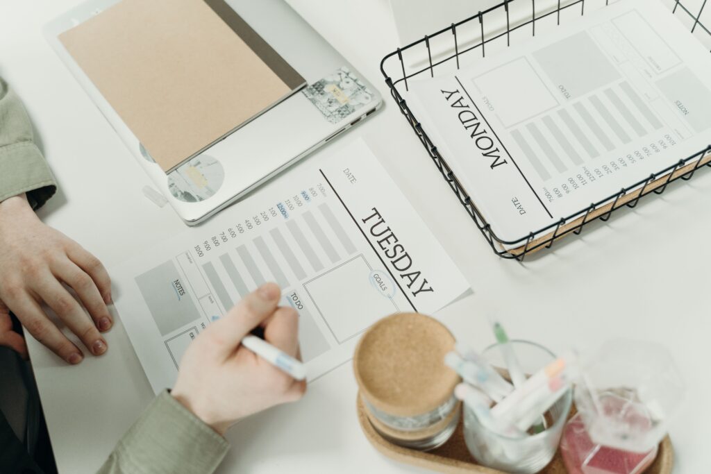 A person organizing their schedule with a planner