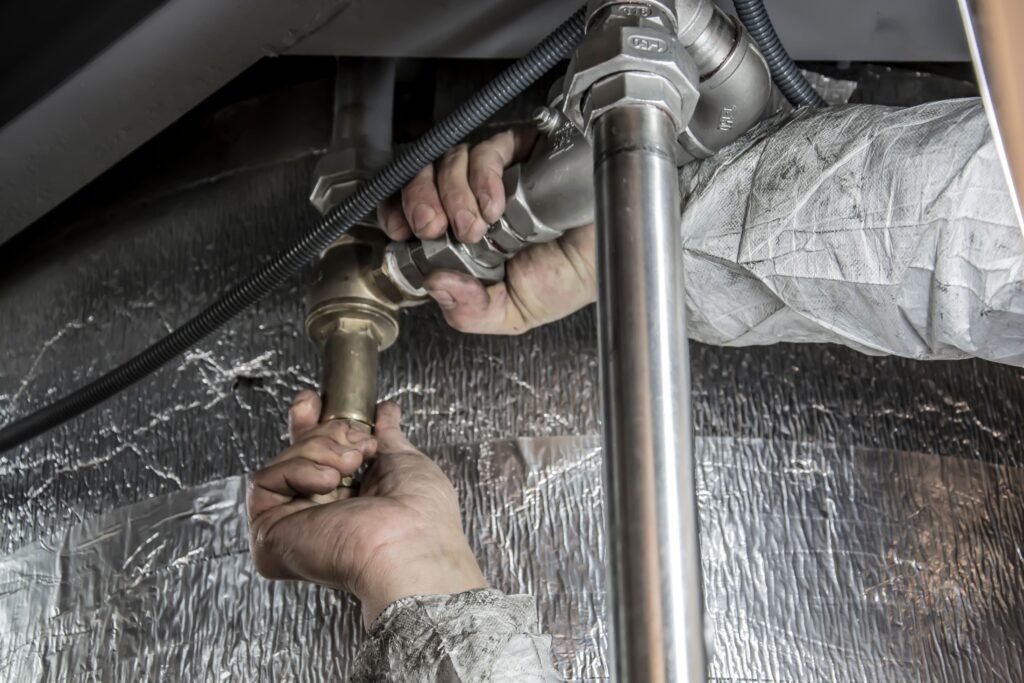Plumber working on a pipe installation in a home